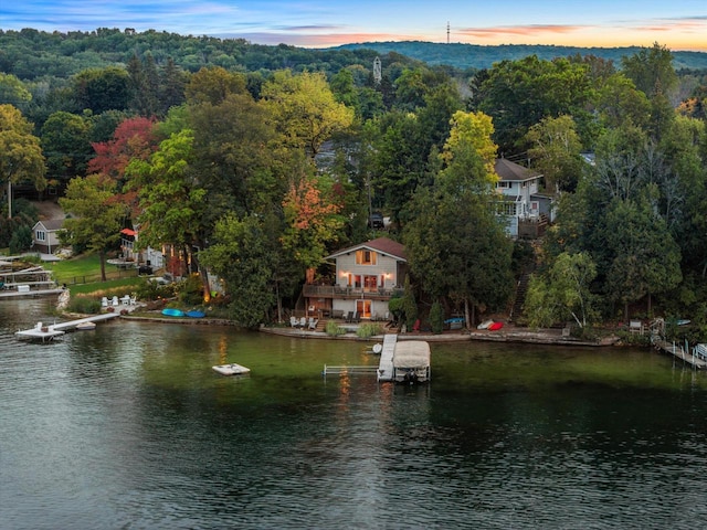 birds eye view of property featuring a forest view and a water view