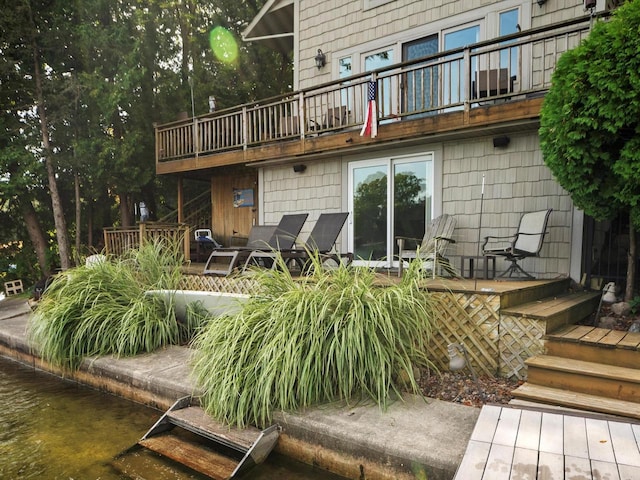 rear view of house with a balcony and a wooden deck