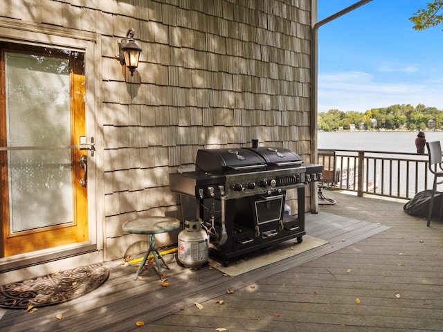 wooden terrace featuring a water view and grilling area