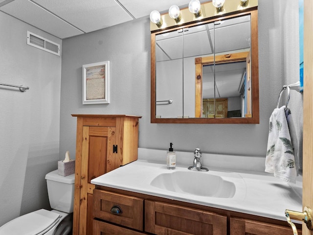 bathroom with visible vents, toilet, and vanity