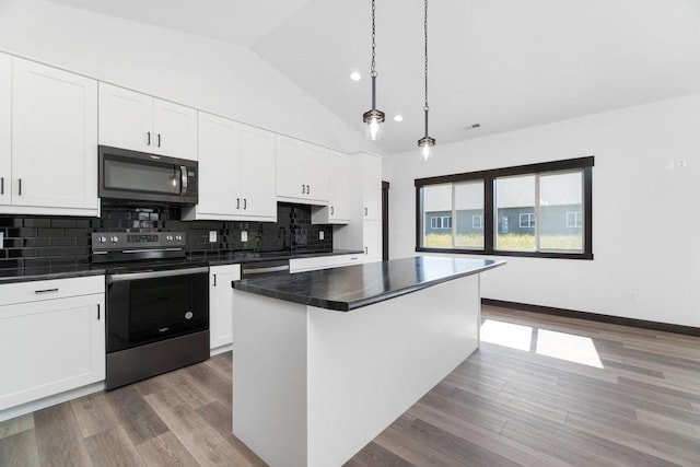 kitchen featuring light wood-type flooring, pendant lighting, stainless steel appliances, a center island, and vaulted ceiling