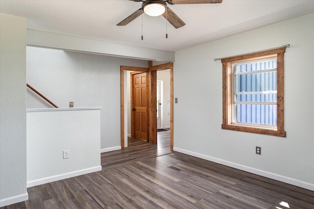 empty room with dark hardwood / wood-style flooring and ceiling fan