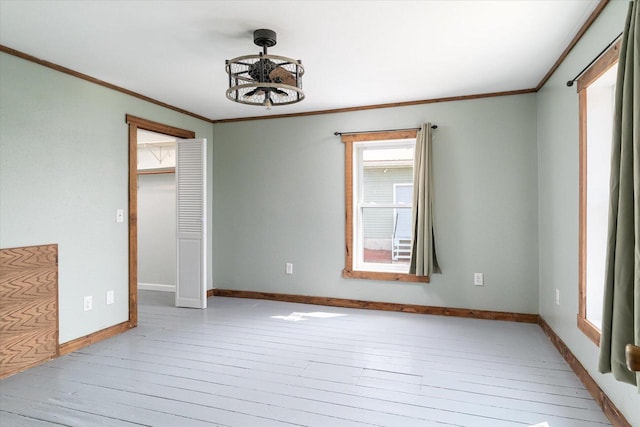 unfurnished room with light wood-type flooring, a chandelier, and ornamental molding