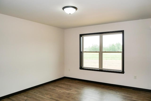 empty room with dark hardwood / wood-style flooring