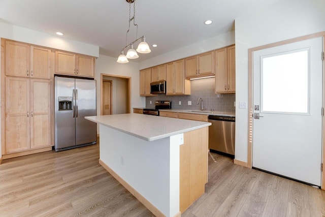 kitchen featuring light hardwood / wood-style flooring, stainless steel appliances, a kitchen island, sink, and light brown cabinets