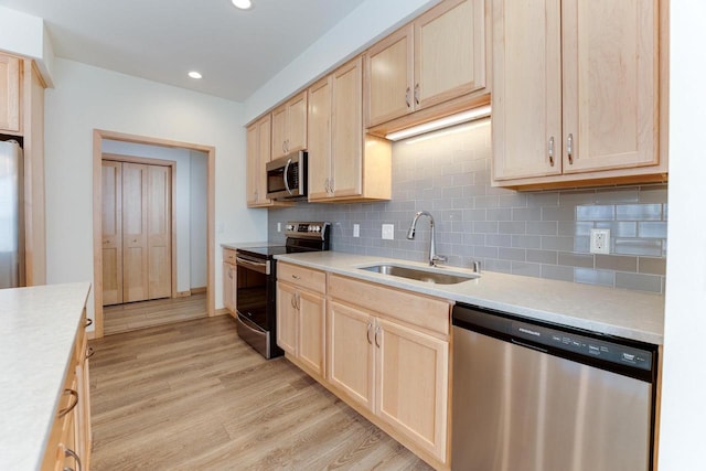 kitchen featuring light hardwood / wood-style flooring, stainless steel appliances, sink, decorative backsplash, and light brown cabinets