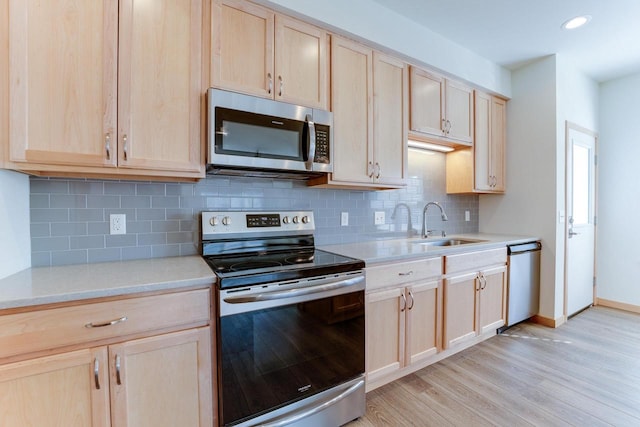 kitchen with light hardwood / wood-style flooring, light brown cabinetry, sink, decorative backsplash, and appliances with stainless steel finishes