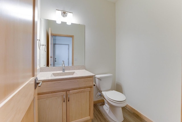 bathroom featuring vanity, toilet, and hardwood / wood-style floors