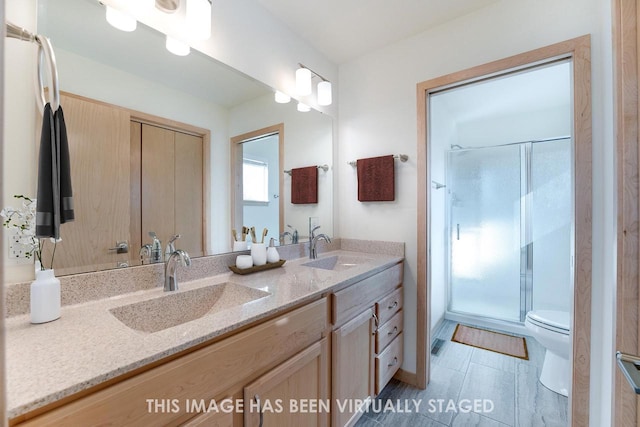 bathroom with vanity, toilet, tile patterned flooring, and a shower with door