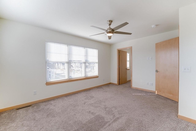 carpeted spare room with ceiling fan