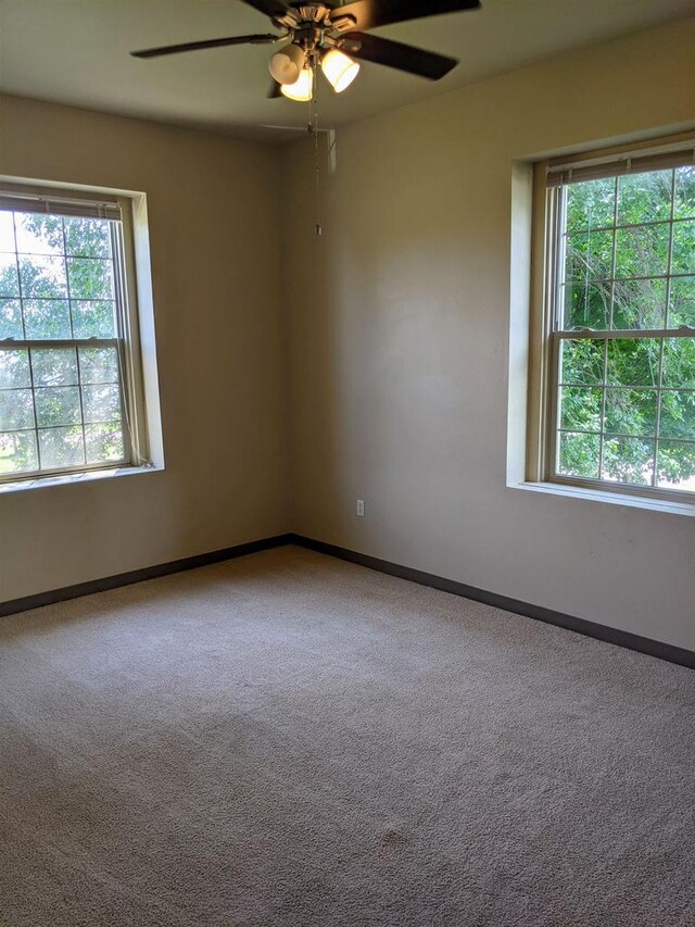 empty room with ceiling fan and carpet flooring