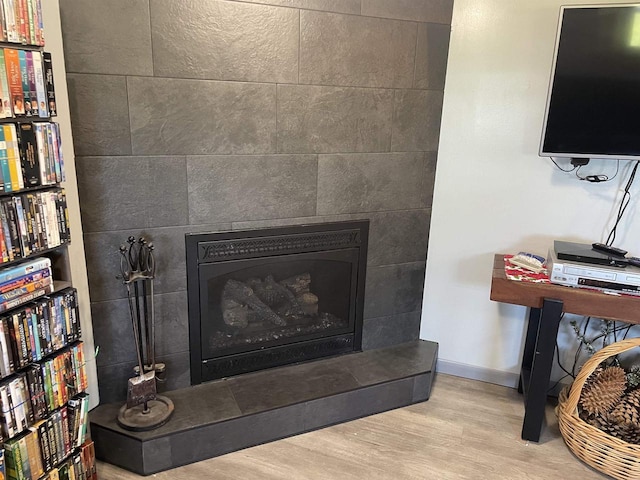 interior details with hardwood / wood-style floors and a tile fireplace