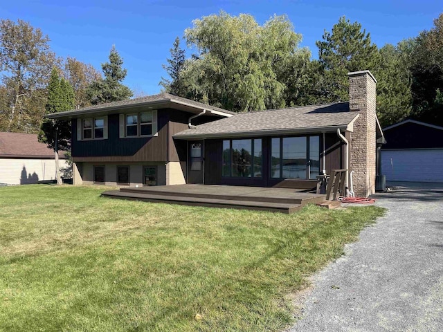 split level home featuring an outdoor structure, a garage, and a front lawn