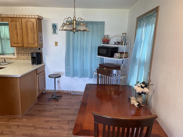 dining area featuring hardwood / wood-style flooring and a notable chandelier