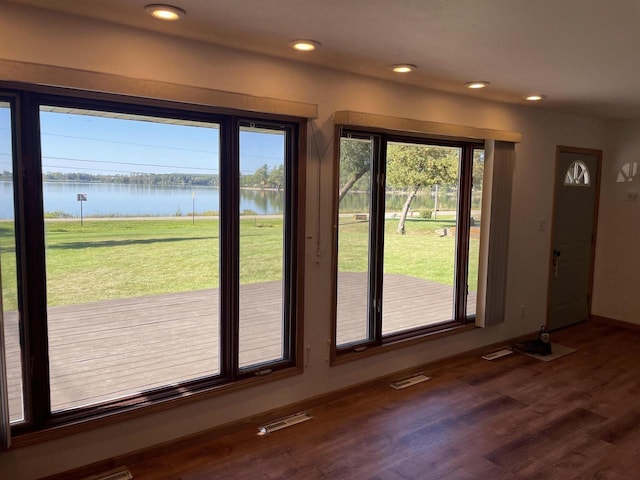 entryway featuring hardwood / wood-style floors and a water view