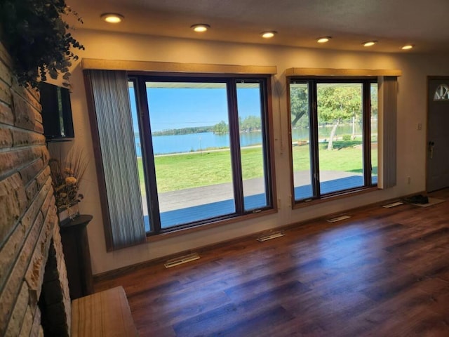 doorway to outside with a water view and dark wood-type flooring