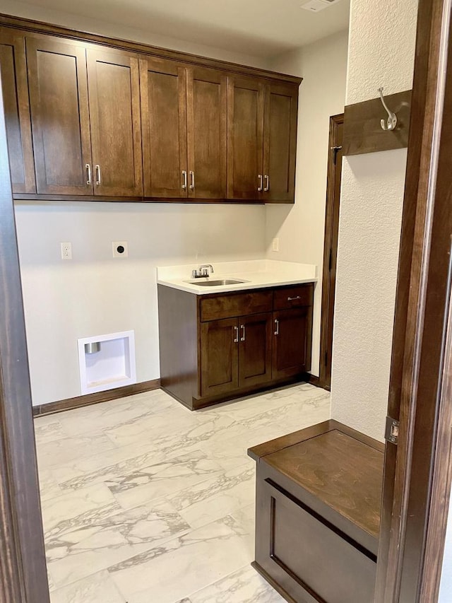 clothes washing area featuring hookup for an electric dryer, cabinets, and sink