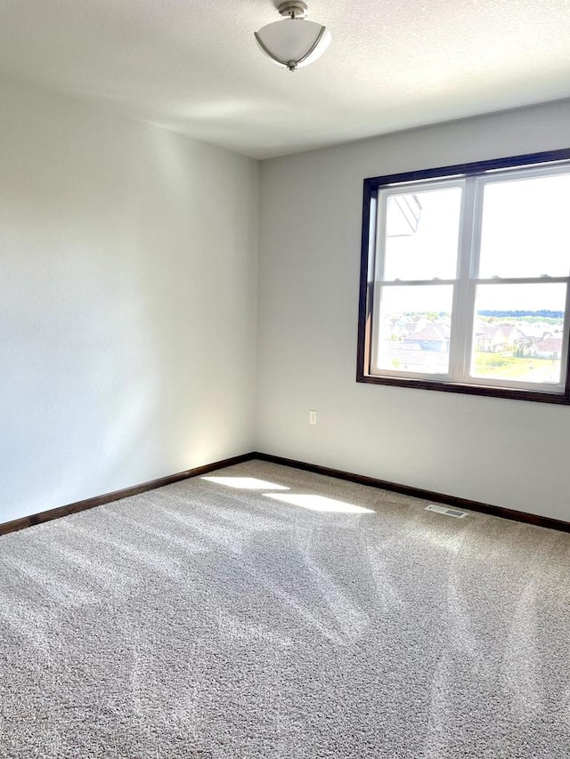 carpeted spare room with a textured ceiling