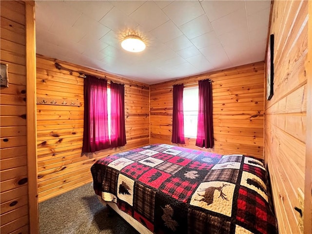 carpeted bedroom with wood walls