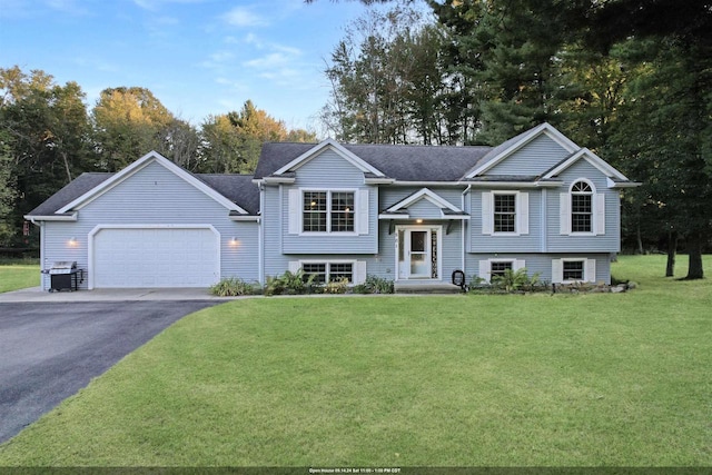 split foyer home featuring a garage and a front lawn