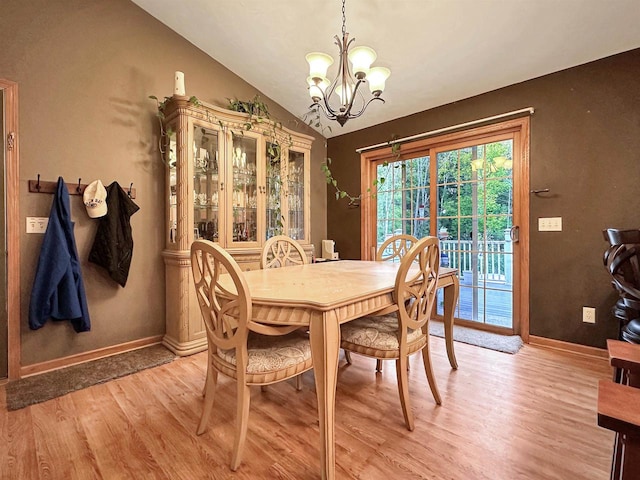 dining room featuring lofted ceiling, a notable chandelier, and light hardwood / wood-style floors