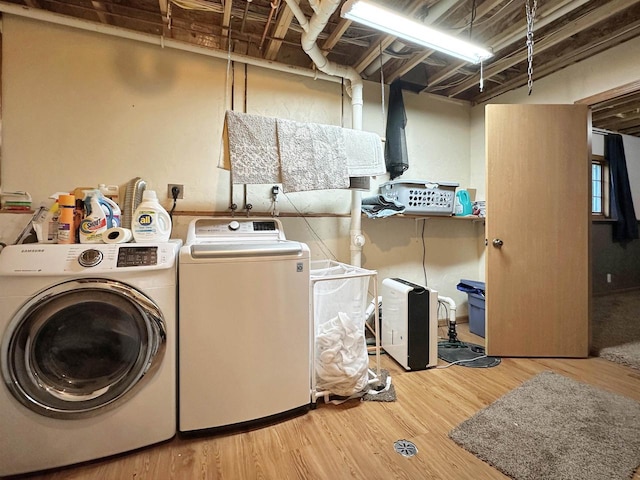 clothes washing area featuring separate washer and dryer and light wood-type flooring