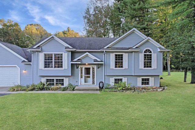 raised ranch featuring a front lawn and a garage