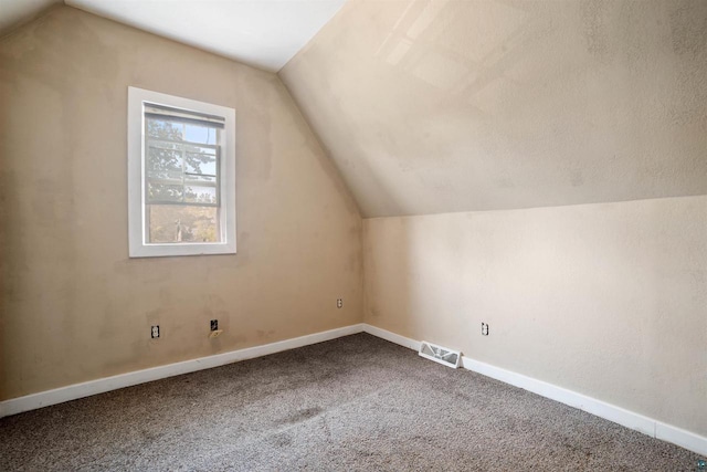 bonus room featuring vaulted ceiling, a textured ceiling, and carpet flooring