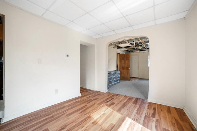 unfurnished room featuring hardwood / wood-style flooring and a paneled ceiling