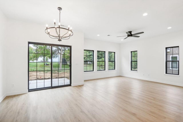 interior space with recessed lighting, ceiling fan with notable chandelier, light wood-type flooring, and baseboards