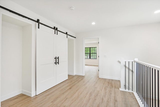 317 Maple St, Pardeeville, WI 53954 - corridor featuring a barn door, light wood-type flooring, baseboards, and recessed lighting