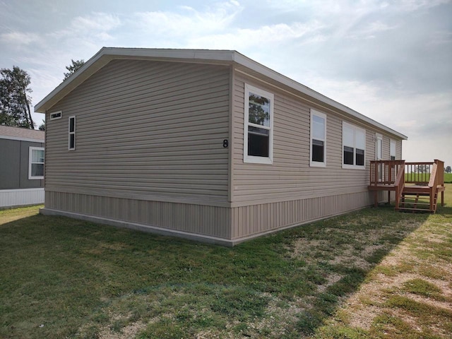 view of side of home with a yard and a wooden deck