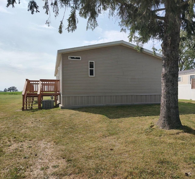 view of side of home featuring a wooden deck, a lawn, and cooling unit