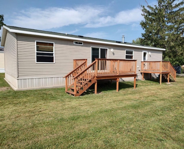 rear view of house with a wooden deck and a yard