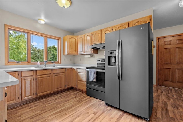 kitchen featuring under cabinet range hood, stainless steel appliances, light wood-style floors, and light countertops