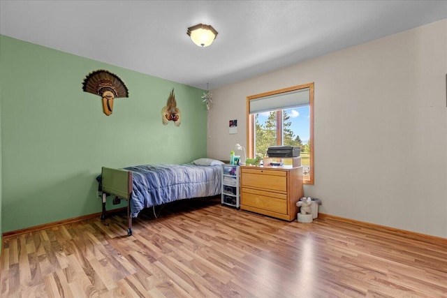 bedroom with baseboards and light wood-type flooring