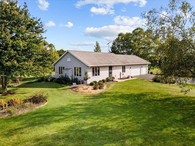 rear view of property with driveway, a lawn, central AC, and an attached garage