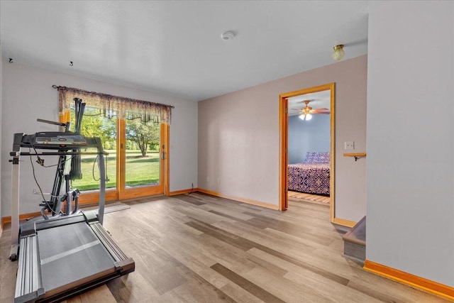 exercise area with baseboards and wood finished floors