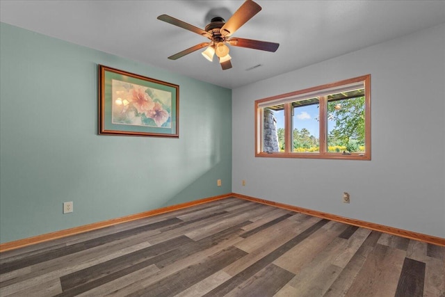 unfurnished room featuring visible vents, wood finished floors, baseboards, and ceiling fan