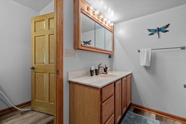 bathroom featuring baseboards, wood finished floors, and vanity