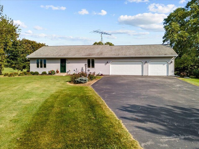 ranch-style home featuring aphalt driveway, a garage, and a front yard