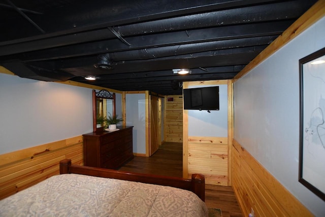 bedroom featuring wood-type flooring and wood walls