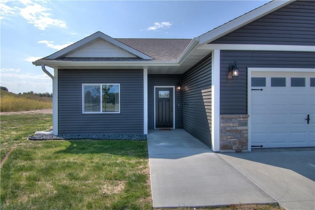 doorway to property featuring a lawn and a garage