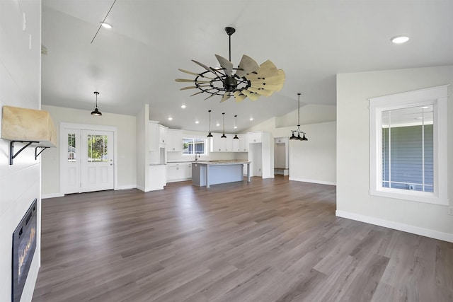 unfurnished living room featuring vaulted ceiling and dark hardwood / wood-style flooring