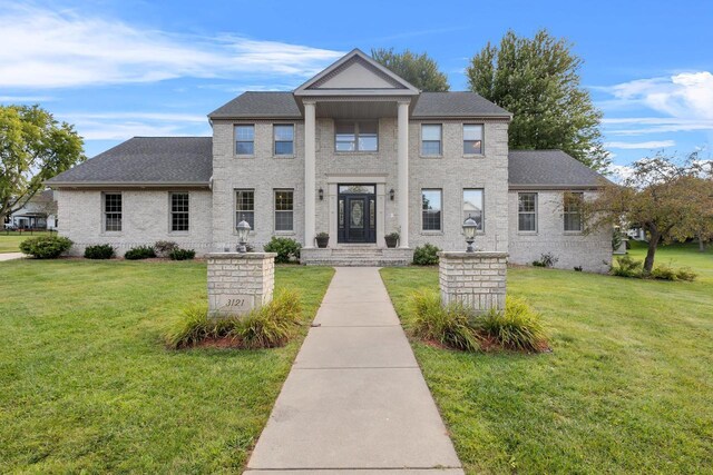 greek revival inspired property featuring a front lawn