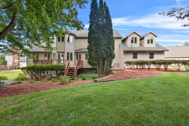 view of front of property with a front yard, central AC unit, and a deck