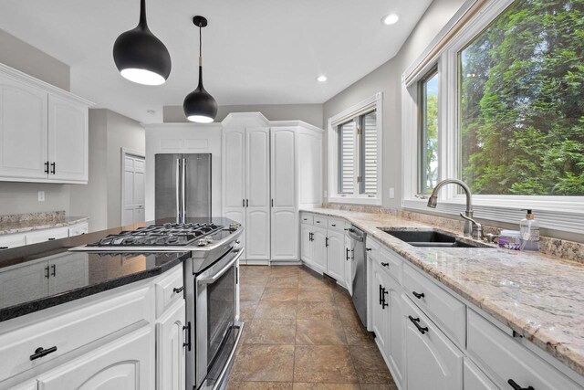 interior space featuring pendant lighting, a notable chandelier, light stone counters, french doors, and dark colored carpet