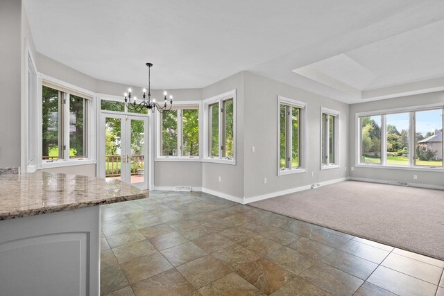 unfurnished living room with carpet and a notable chandelier