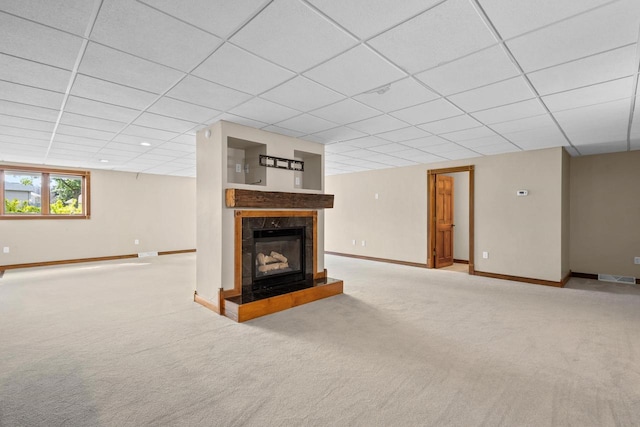 unfurnished living room with light carpet, a tile fireplace, and a drop ceiling