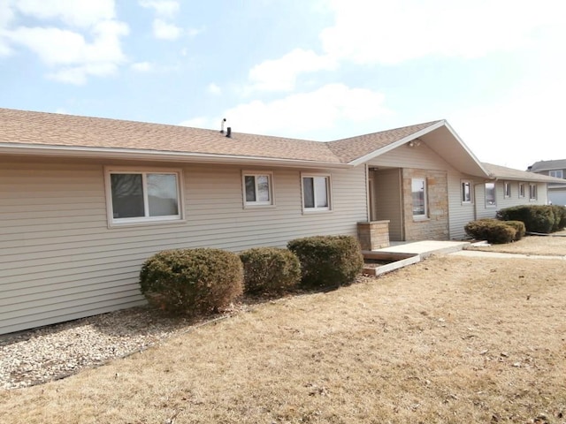 back of property featuring roof with shingles